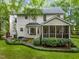 Backyard featuring a screened porch, bay window, landscaped garden beds, and manicured lawn at 118 Cavendish Ct, Hillsborough, NC 27278
