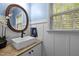 Bathroom with a modern sink, wooden countertop, and window providing natural light at 118 Cavendish Ct, Hillsborough, NC 27278