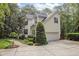 Side view of the home with an attached garage, well-maintained landscaping and lush foliage at 118 Cavendish Ct, Hillsborough, NC 27278