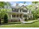 Traditional two-story home with a covered front porch, black shutters, and mature landscaping at 118 Cavendish Ct, Hillsborough, NC 27278