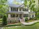 Charming two-story home with a covered front porch, mature trees, and well-manicured lawn at 118 Cavendish Ct, Hillsborough, NC 27278