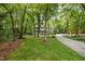 Landscaped front yard and long driveway lead to a charming home nestled among mature trees at 118 Cavendish Ct, Hillsborough, NC 27278