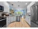 Well-lit kitchen with stainless steel appliances, white cabinets, and hardwood floors, perfect for cooking at 118 Cavendish Ct, Hillsborough, NC 27278