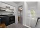 Well-organized laundry room with shelving and modern black washer and dryer at 118 Cavendish Ct, Hillsborough, NC 27278