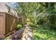 A cozy walkway extending through a backyard that is canopied by shade trees, and adorned with lush greenery at 119 Brookberry Cir, Chapel Hill, NC 27517