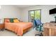 Bright bedroom with an orange quilted bedspread, wooden furniture, and a sliding glass door to the outside at 119 Brookberry Cir, Chapel Hill, NC 27517