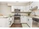 Updated kitchen showcasing white cabinets, stainless steel appliances, granite countertops, and hardwood floors at 119 Brookberry Cir, Chapel Hill, NC 27517