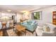 The open-concept living room is bright, and features stylish furnishings and a view into the private backyard at 119 Brookberry Cir, Chapel Hill, NC 27517