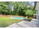 Spacious backyard featuring an in-ground pool, lush lawn, and a privacy fence surrounded by mature trees at 1209 Lanark Ct, Cary, NC 27511