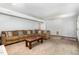 Spacious finished basement features neutral carpeting, and a large sectional sofa with pillows at 1209 Lanark Ct, Cary, NC 27511