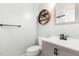 A modern half bathroom with a gray vanity, round wood shelf, and neutral paint at 1209 Lanark Ct, Cary, NC 27511