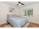 Cozy bedroom with a ceiling fan, natural light, and a queen size bed with blue patterned quilt at 1209 Lanark Ct, Cary, NC 27511