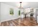 Dining area with wood floors flows into a modern kitchen, offering stainless steel appliances and natural light at 1209 Lanark Ct, Cary, NC 27511