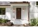 Close-up of a beautiful front porch and a wood front door with sidelights and elegant outdoor lighting fixtures at 1209 Lanark Ct, Cary, NC 27511