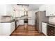 A bright and open kitchen featuring white cabinets, stainless steel appliances, and hardwood floors at 1209 Lanark Ct, Cary, NC 27511