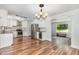 Bright eat-in kitchen with stainless appliances, white cabinetry, hardwood floors and adjacent living space at 1209 Lanark Ct, Cary, NC 27511