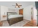 A cozy main bedroom featuring wood floors, a ceiling fan, a sliding barn door, and neutral decor at 1209 Lanark Ct, Cary, NC 27511