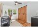 Bright office space featuring a barn door, hardwood floors, ceiling fan, and a large window at 1209 Lanark Ct, Cary, NC 27511