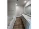 Bathroom with double sinks, granite counters, vinyl flooring, and a soaking tub at 128 Coharie Dr, Lillington, NC 27546