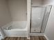 Bathroom featuring a soaking tub and separate shower stall with a glass door at 128 Coharie Dr, Lillington, NC 27546
