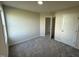 Bright bedroom with neutral walls, plush carpet, and a doorway leading to another room at 128 Coharie Dr, Lillington, NC 27546