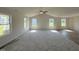 Open floor plan featuring vaulted ceiling with fan, carpet in the living room and hardwood floor accent at 128 Coharie Dr, Lillington, NC 27546