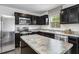 A modern kitchen with stainless steel appliances, dark cabinets, and granite countertops, perfect for cooking at 1537 Ivy Meadow Ln, Zebulon, NC 27597