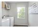 Well-lit laundry room including a washer, dryer, and shelving for storage and organization at 1537 Ivy Meadow Ln, Zebulon, NC 27597