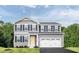 Charming two-story home with gray siding, black shutters, yellow door, and two-car garage at 1541 Ivy Meadow Ln, Zebulon, NC 27597