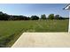 Expansive backyard boasts a concrete patio and a large green lawn area, with views of trees at 166 Coharie Dr, Lillington, NC 27546