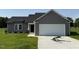 Charming single-story home featuring gray siding and a two-car garage on a green lot at 166 Coharie Dr, Lillington, NC 27546