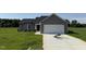 Charming single-story home featuring gray siding and a two-car garage on a green lot at 166 Coharie Dr, Lillington, NC 27546