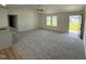 Open-concept living room with carpet, large windows, vaulted ceilings, and easy access to the kitchen at 179 Coharie Dr, Lillington, NC 27546