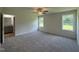 Carpeted main bedroom features a ceiling fan, windows, and an ensuite bathroom at 179 Coharie Dr, Lillington, NC 27546
