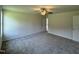 Spacious carpeted main bedroom with a ceiling fan, two windows, and a door to the ensuite bathroom at 179 Coharie Dr, Lillington, NC 27546
