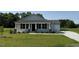 Charming single-story home with a well-manicured lawn and a covered front porch at 206 Coharie Dr, Lillington, NC 27546