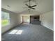 Bright living room with new carpet, a ceiling fan, and a view of the backyard at 206 Coharie Dr, Lillington, NC 27546
