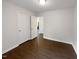 A bedroom with wood-look floors features white walls, two white doors, and an open doorway at 216 E Hinton St, Clayton, NC 27520