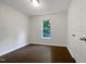 An empty bedroom boasts neutral walls, wood-look flooring, a window, and a flush-mount light fixture at 216 E Hinton St, Clayton, NC 27520
