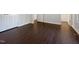 An empty room with freshly cleaned hardwood floors and a door leading into the hallway and bedrooms at 216 E Hinton St, Clayton, NC 27520