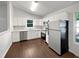 Modern kitchen with white cabinets, stainless steel appliances, and marble countertops, with new hardwood floors at 216 E Hinton St, Clayton, NC 27520