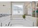 Soaking tub with decorative window and tile surround at 240 Paddy Ln, Youngsville, NC 27596