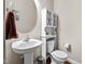 Charming powder room with pedestal sink, oval mirror, and white storage cabinet at 240 Paddy Ln, Youngsville, NC 27596