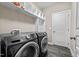 Convenient laundry room featuring front load Samsung washer and dryer and built-in shelving at 240 Paddy Ln, Youngsville, NC 27596