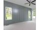 Spacious bedroom with paneled accent wall, neutral carpet, and bright windows showing the lush exterior at 25 Alex Farm Ct, Zebulon, NC 27597