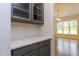 Charming butler's pantry with quartz countertops, white brick backsplash, gray cabinets, and gold hardware at 25 Alex Farm Ct, Zebulon, NC 27597