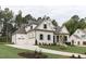 Beautifully landscaped yard showcasing a spacious three-car garage and manicured front lawn at 25 Alex Farm Ct, Zebulon, NC 27597