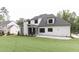 Spacious backyard with lush lawn, stone patio, and view of the home's exterior at 25 Alex Farm Ct, Zebulon, NC 27597