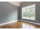 A bright living room features hardwood floors, natural light from a large window, and vaulted ceilings at 25 Alex Farm Ct, Zebulon, NC 27597