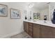 Bright bathroom featuring double sinks, framed art, a large mirror, and neutral-toned cabinets with decorative hardware at 27 Cribbs Ln, Middlesex, NC 27557